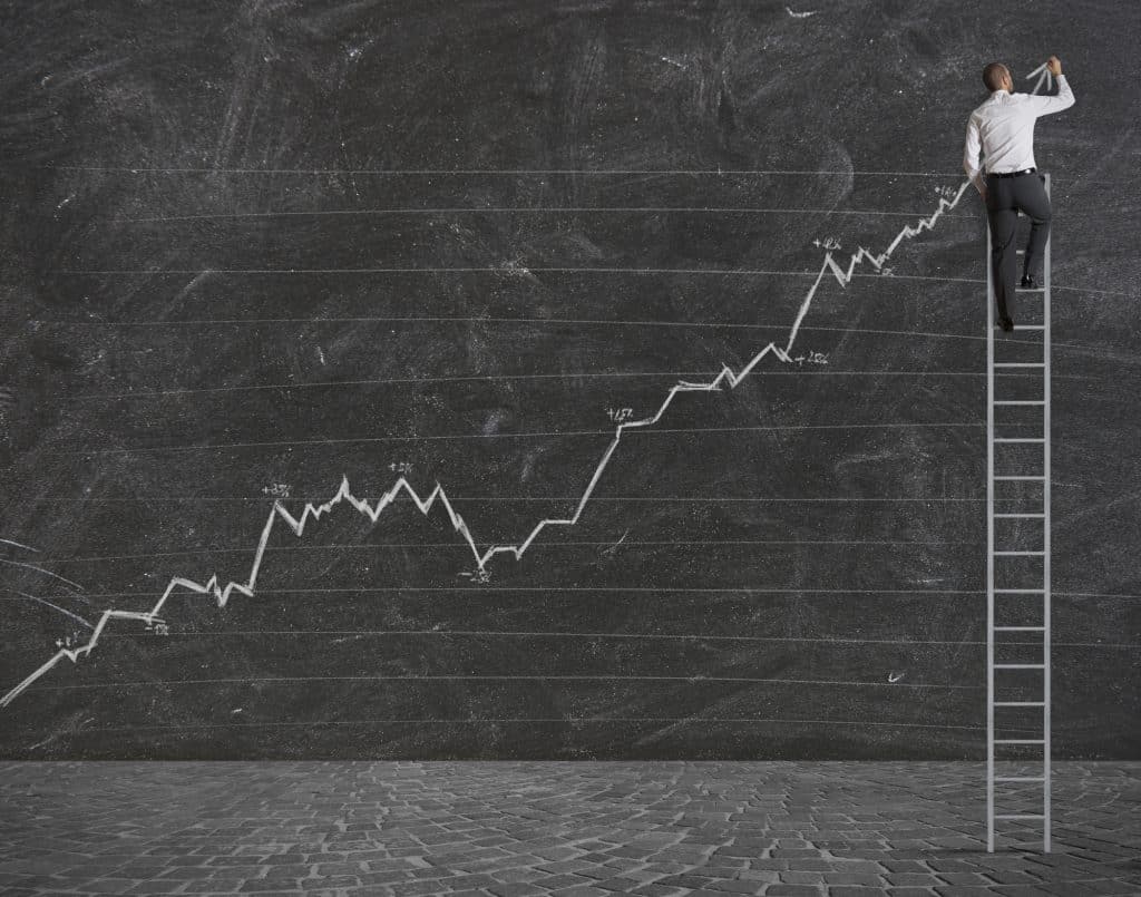a man on a ladder drawing a positive statistical trend