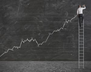 a man on a ladder drawing a positive statistical trend